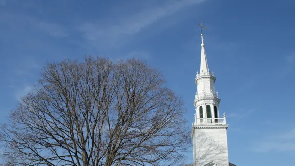 The white-steepled Avon Congregational Church beside a bare shade tree on the town green in Avon, Connecticut